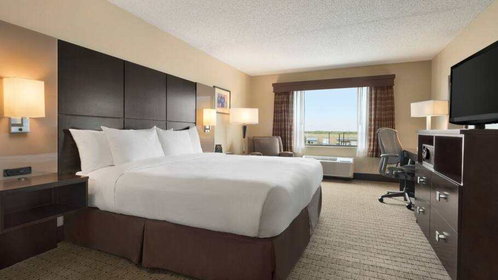 Bright king bedroom with window at the DoubleTree by Hilton Wichita Airport.