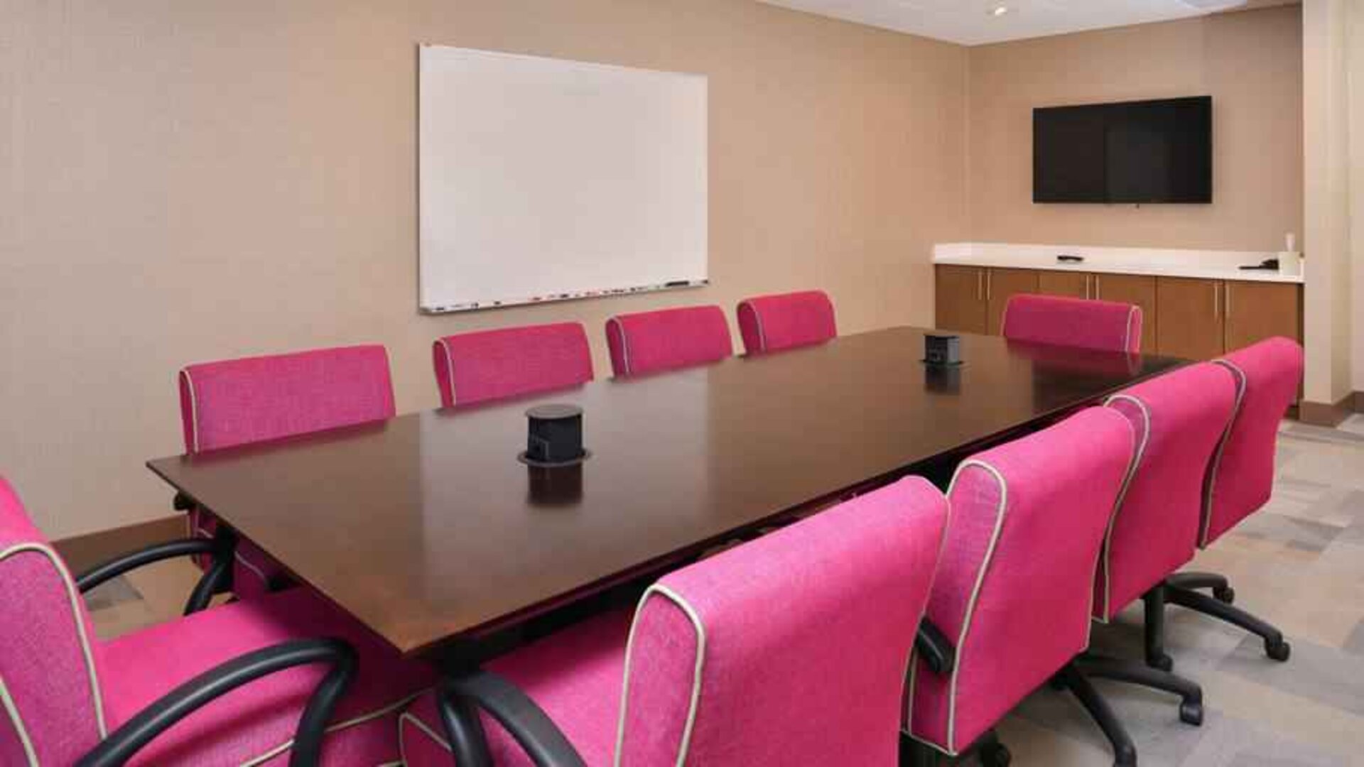 Small meeting room with pink chairs at the Hampton Inn & Suites St. Paul Oakdale/Woodbury by Hilton.