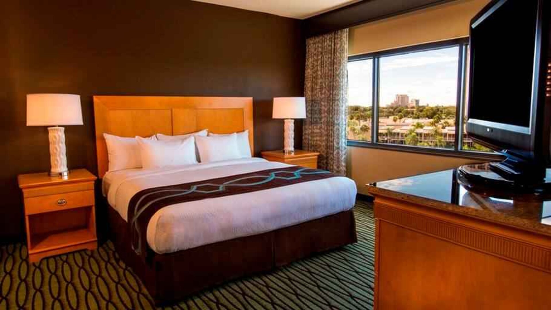 King suite with TV screen and window at the DoubleTree Suites by Hilton Orlando - Disney Springs Area.