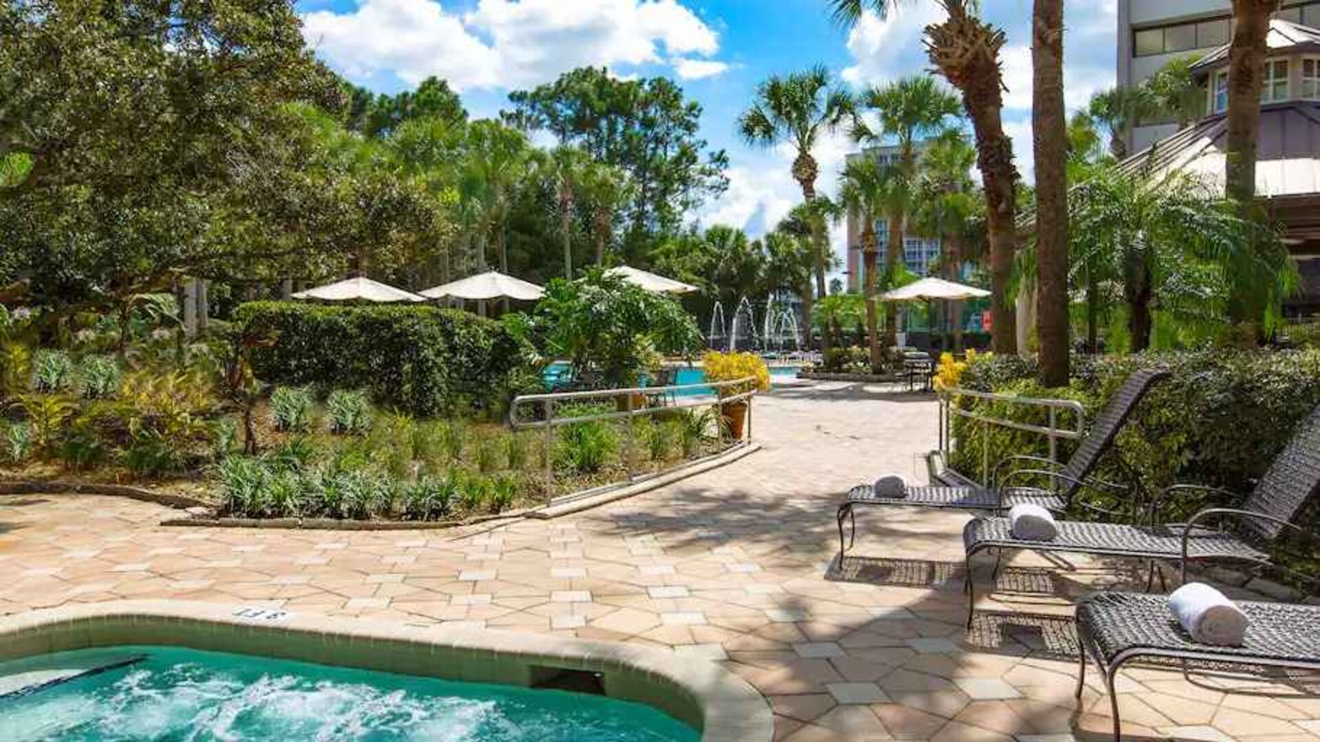 Beautiful outdoor patio with plants by the pool at the DoubleTree Suites by Hilton Orlando - Disney Springs Area.