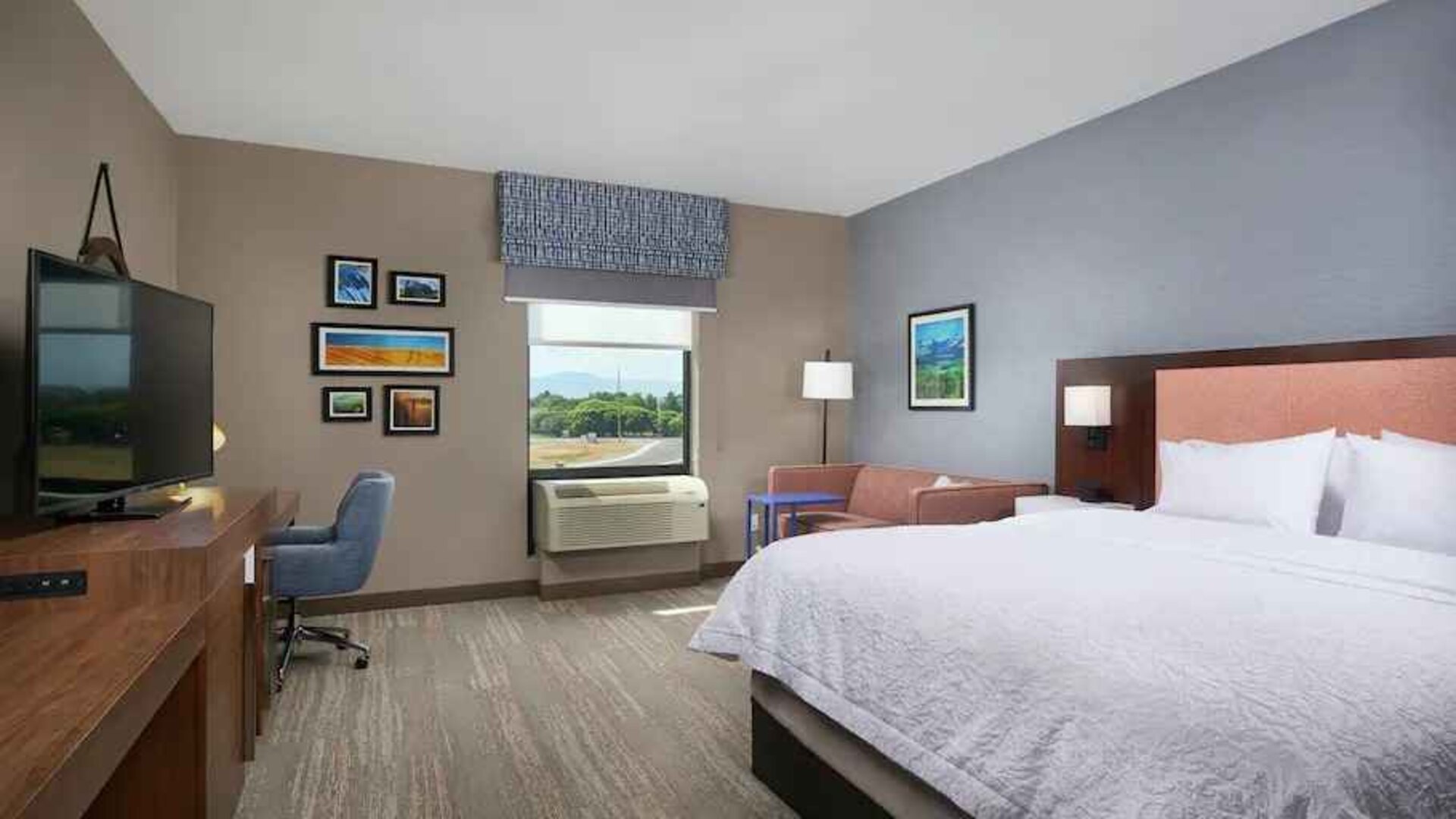 King bedroom with desk, window and sofa at the Hampton Inn Burley.