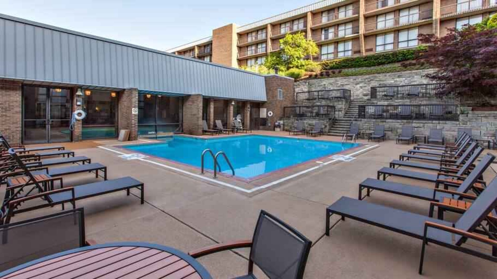 Outdoor pool with lounges at the DoubleTree by Hilton Pittsburgh Green Tree.
