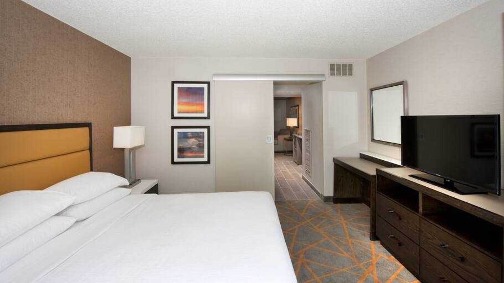 Comfortable bedroom in a king suite at the Embassy Suites by Hilton Cincinnati Blue Ash.
