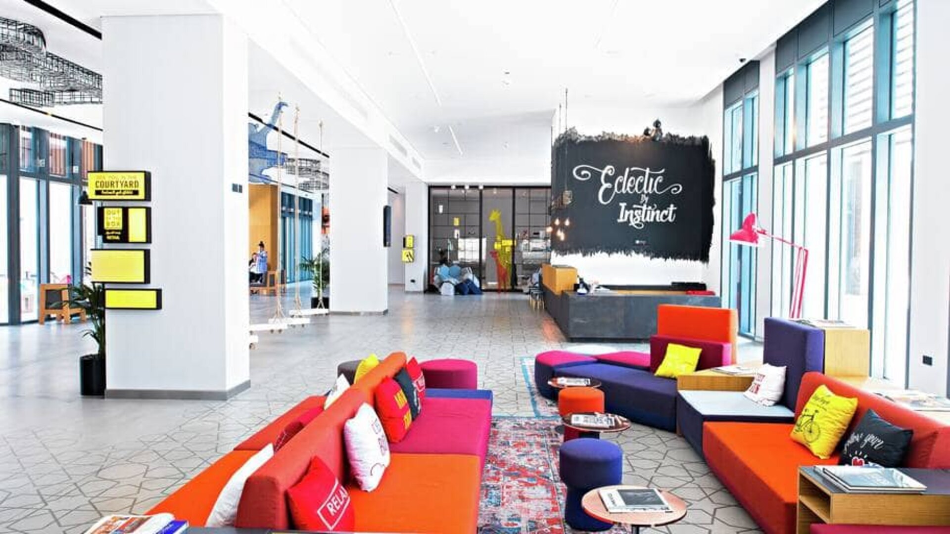 Colorful chairs and couches fill this eclectic stimulating hotel lounge area at Hilton Dubai Al Seef.