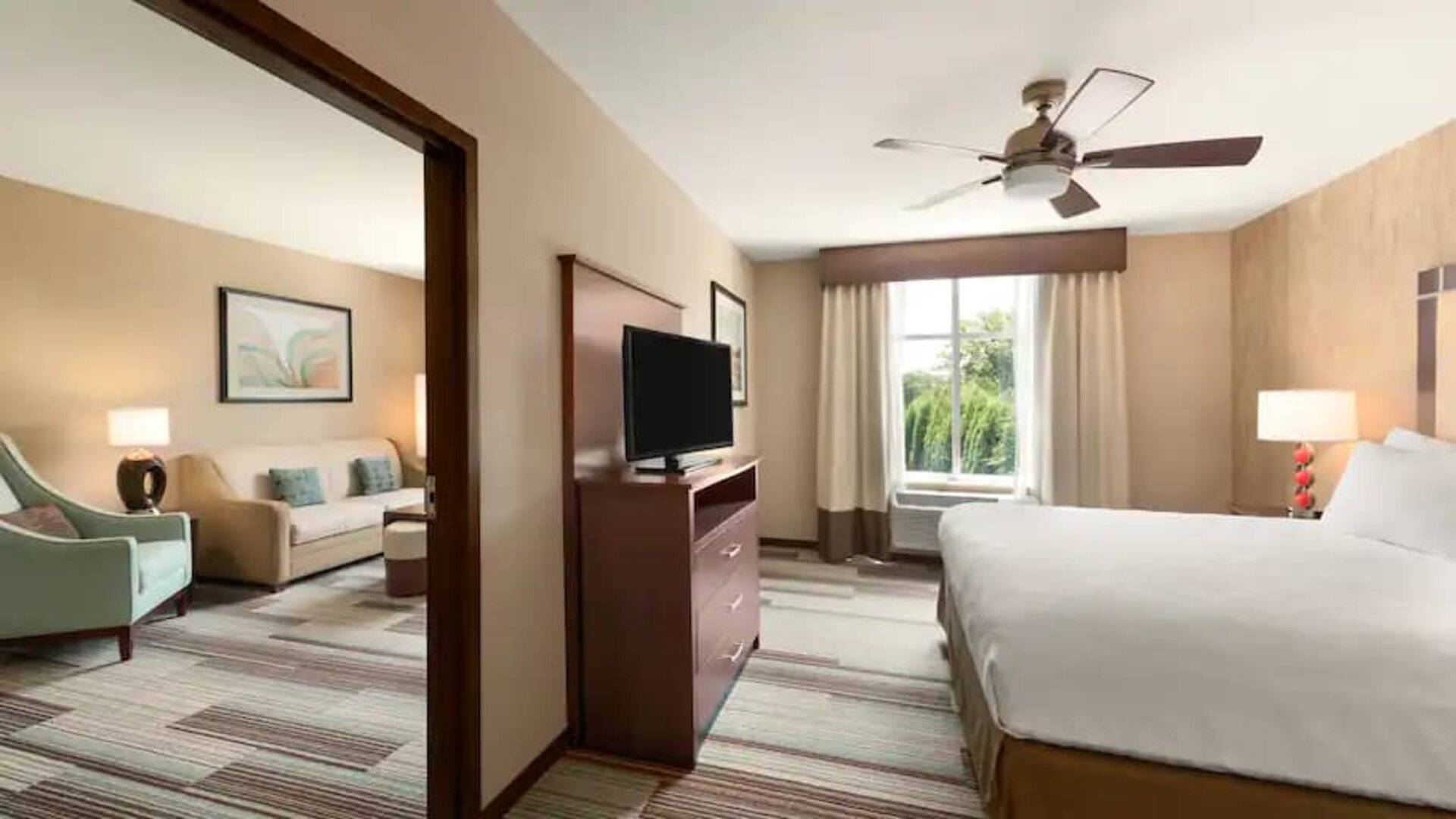 Spacious queen suite with features of a home at the Homewood Suite by Hilton Atlanta Perimeter.