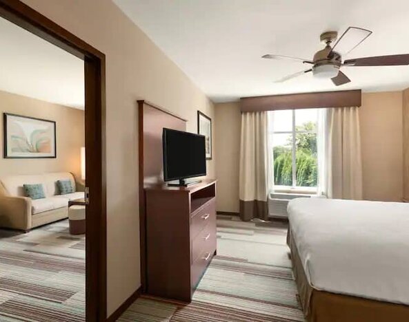 Spacious queen suite with features of a home at the Homewood Suite by Hilton Atlanta Perimeter.