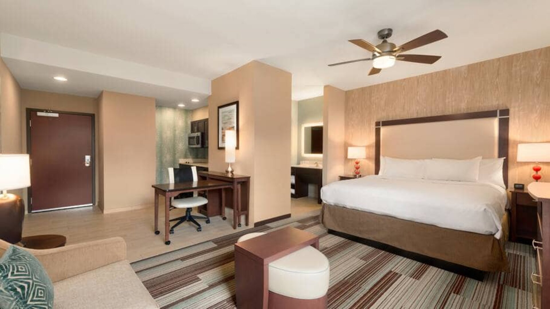 Open layout king size suite with king bed, tv, and kitchenette at the Homewood Suite by Hilton Atlanta Perimeter.