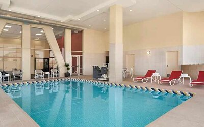 Lovely indoor pool with surrounding seating area and sun beds at Homewood Suites by Hilton University City Philadelphia, PA.