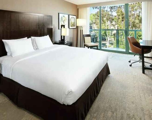 beautiful king suite with TV and work desk with lots of natural light and a terrace at DoubleTree by Hilton Hotel San Diego - Hotel Circle.