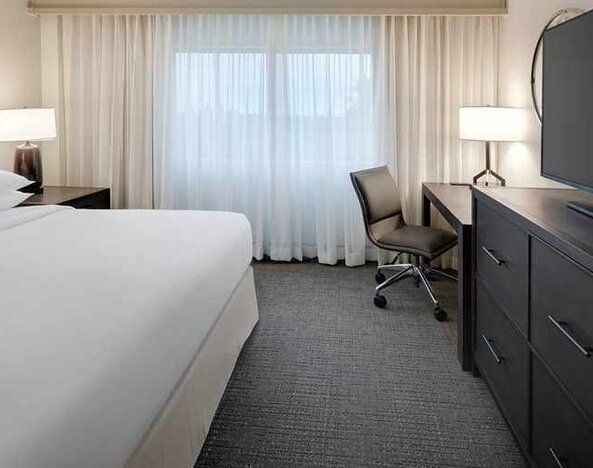 comfortable king room with TV and work desk ideal for working remotely at Embassy Suites by Hilton Detroit Troy Auburn Hills.