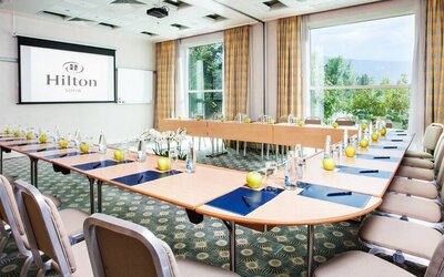 Wide u-shaped area for seating for 20-30 guests, large projection screen in center and windows all around.