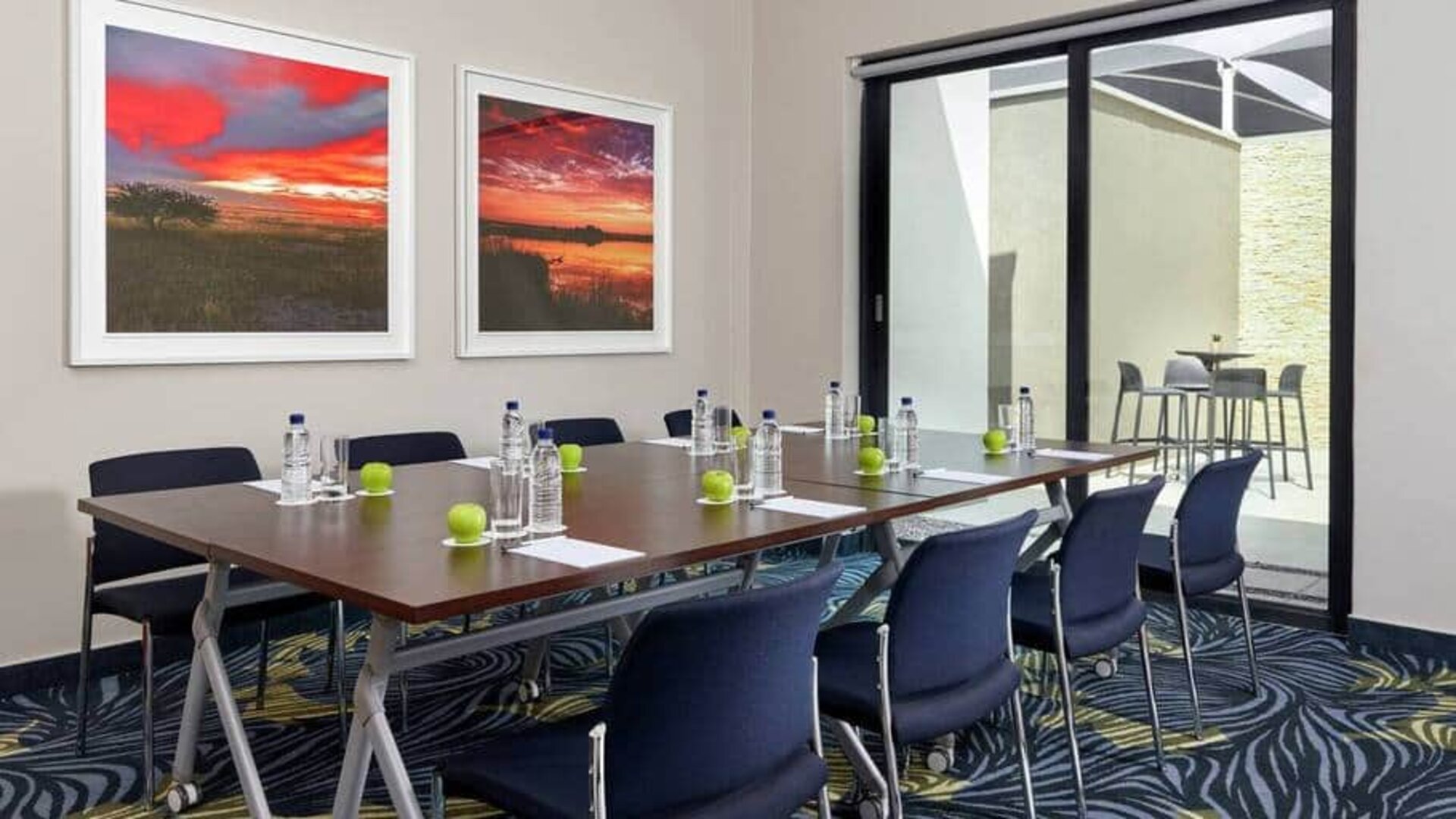 Small meeting room with rectangular table and seating for 8 guests.