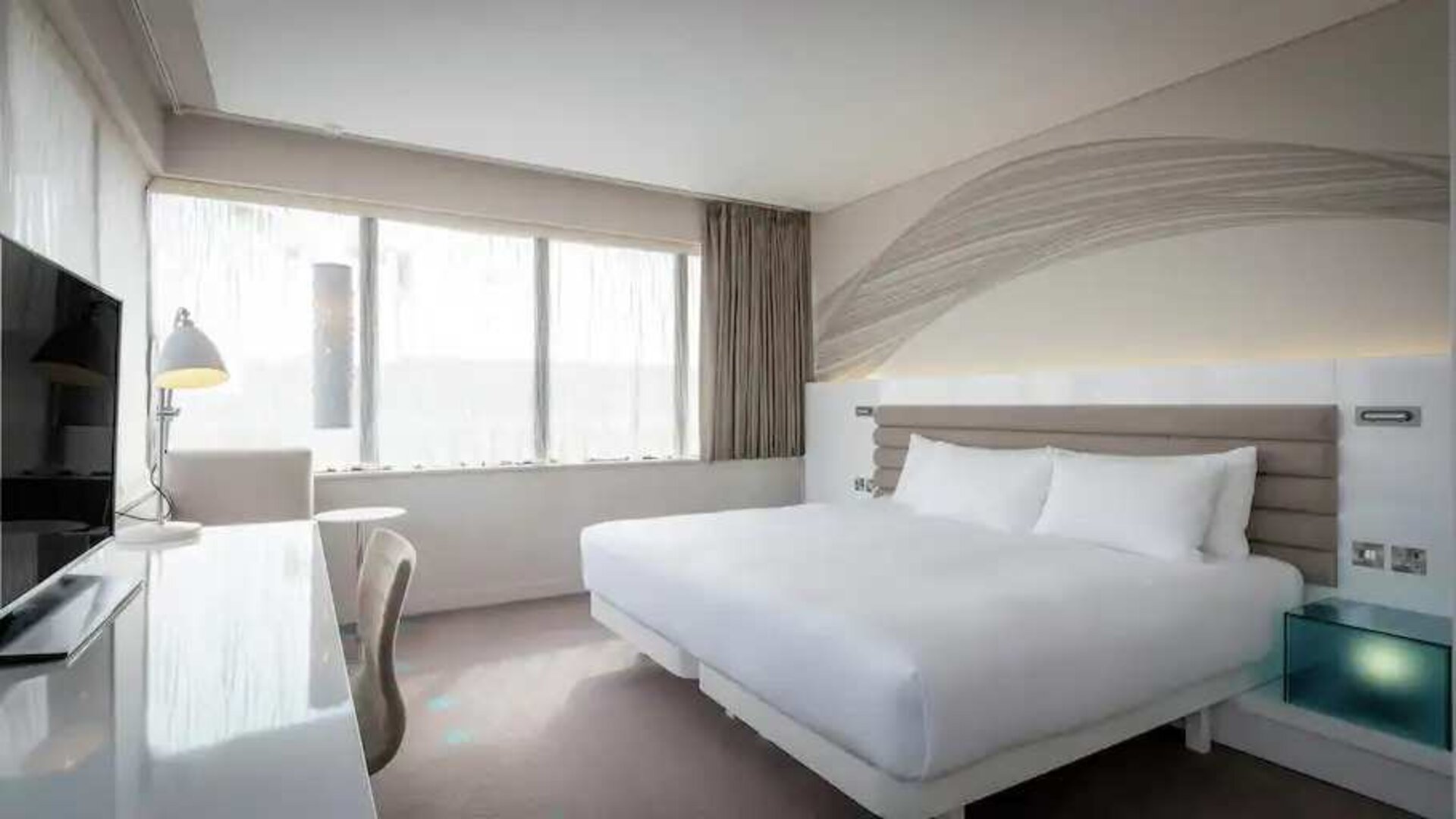 King bedroom with TV screen and desk at the Morrison, a DoubleTree by Hilton Hotel.