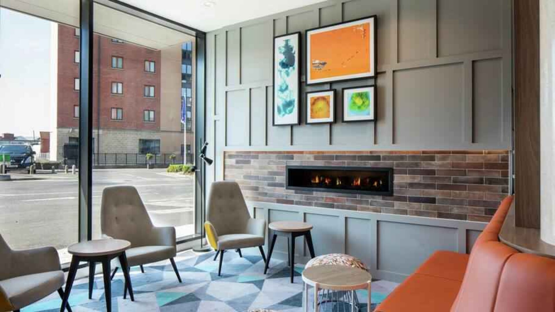 Lobby workspace by the fireplace at the Hampton by Hilton Belfast City Centre.