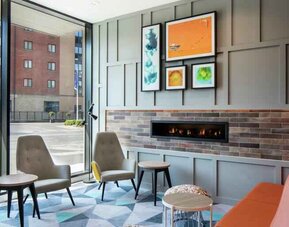 Lobby workspace by the fireplace at the Hampton by Hilton Belfast City Centre.
