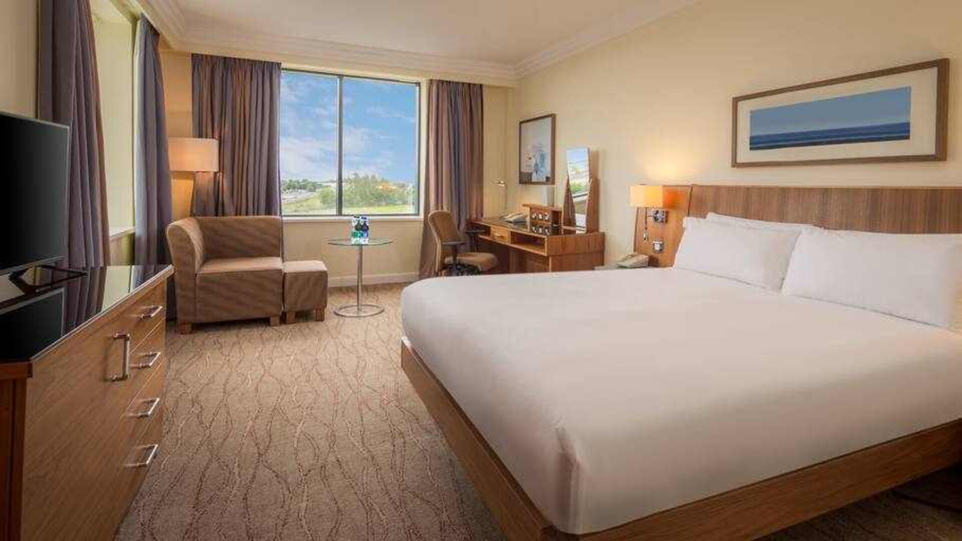 King bedroom with sofa, TV screen and desk at the Hilton Dublin Airport.