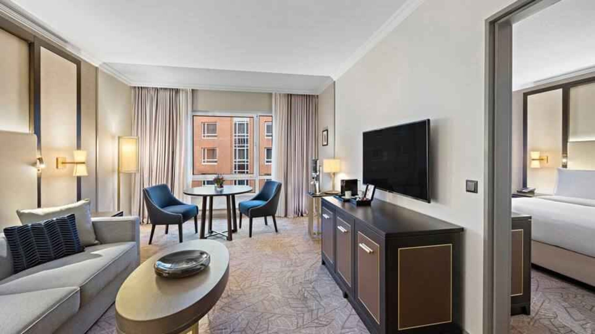 Spacious living room with working station by the window at the Hilton Munich City.