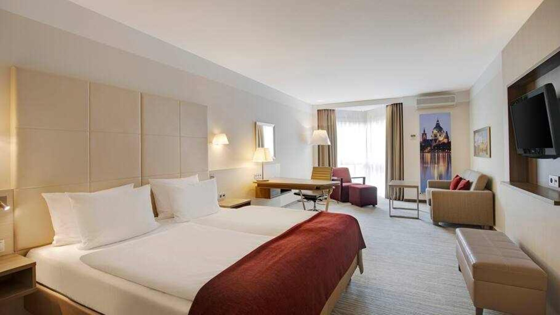 King bedroom with desk, sofa and TV screen at the DoubleTree by Hilton Hannover Schweizerhof.