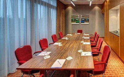Meeting room with large windows at the Hilton Garden Inn Frankfurt Airport.