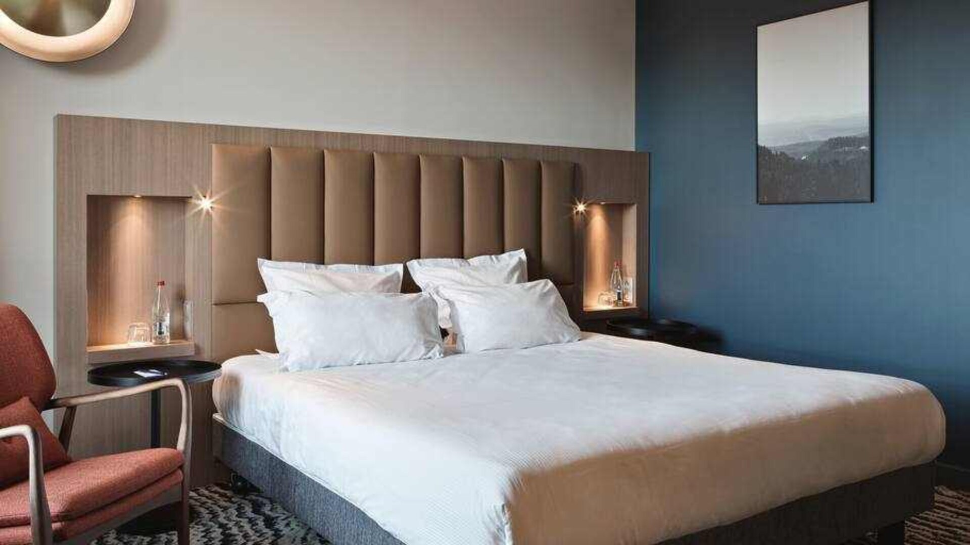 Queen room with bed and a comfortable chair at the DoubleTree by Hilton Lyon Eurexpo.