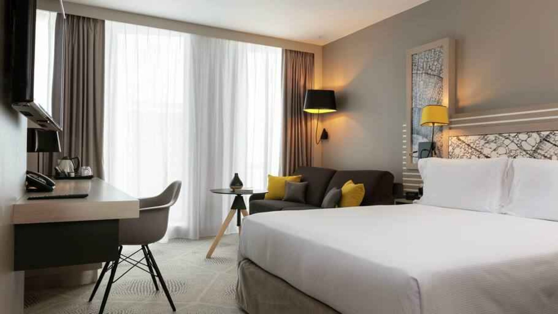 King bedroom with desk and sofa at the Hilton Garden Inn Bordeaux Centre.