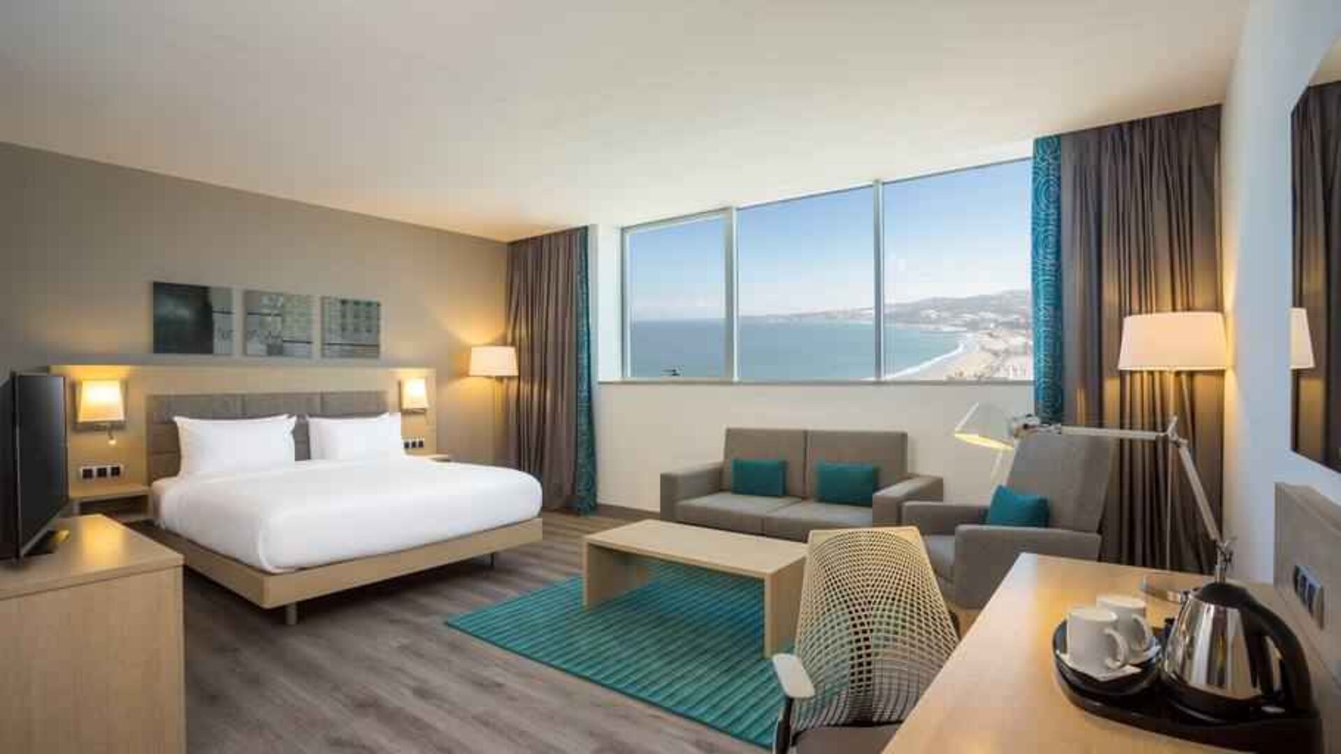 Spacious king bedroom with sofa and desk at the Hilton Garden Inn Tanger City Center.