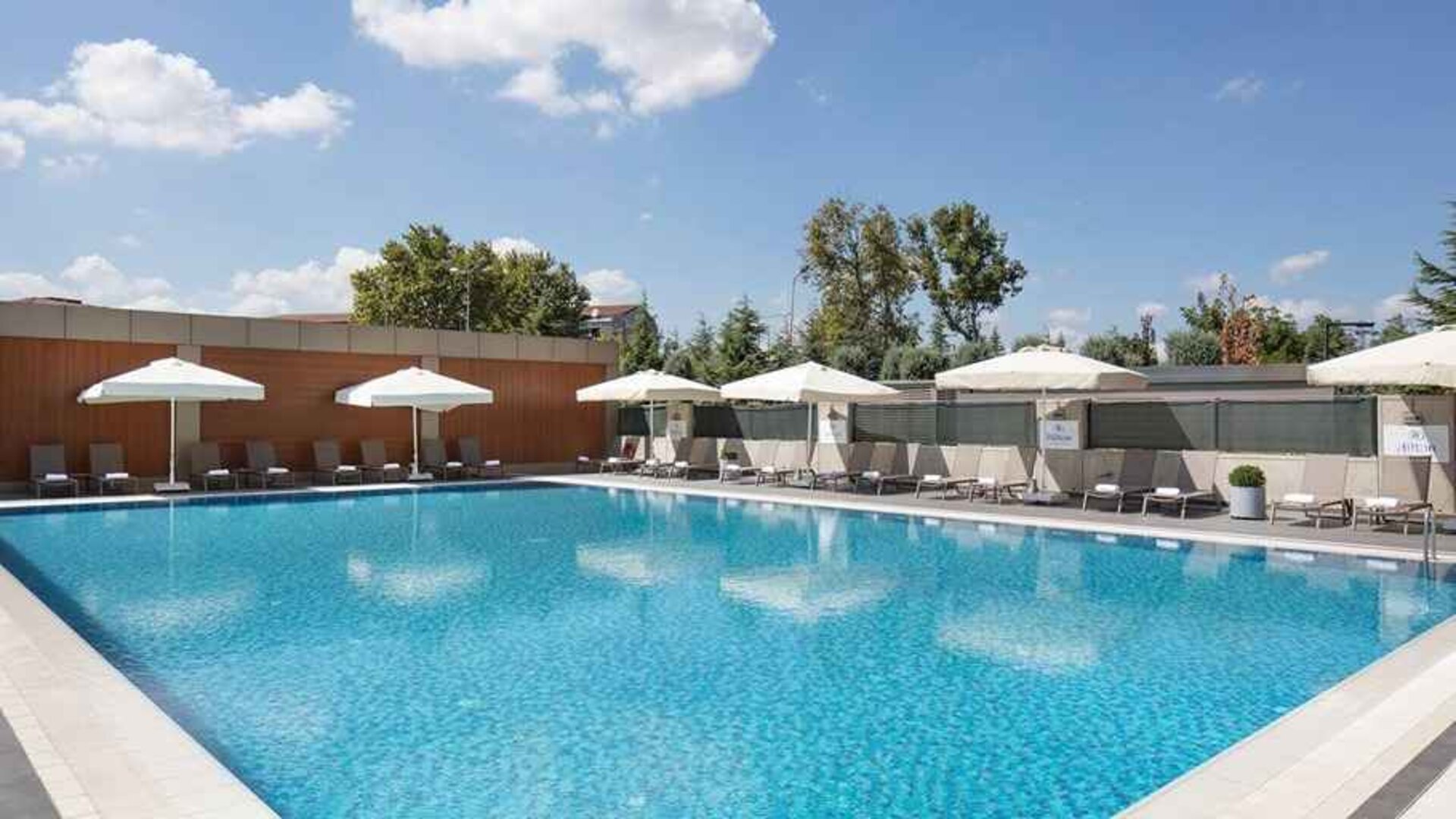 stunning outdoor pool with sun beds and umbrellas at Hilton Istanbul Bakirkoy.