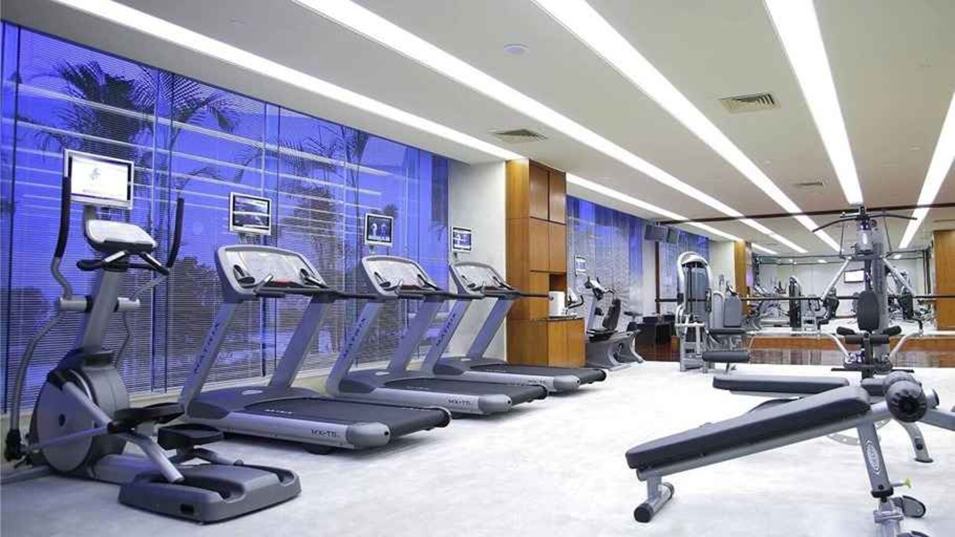 well equipped fitness center with treadmills, bikes, and weights at Hilton Guangzhou Science City.