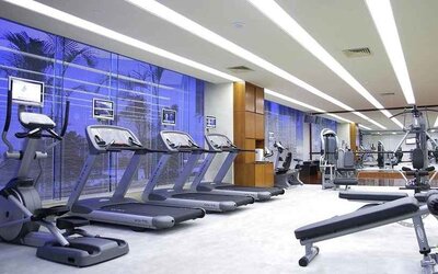 well equipped fitness center with treadmills, bikes, and weights at Hilton Guangzhou Science City.
