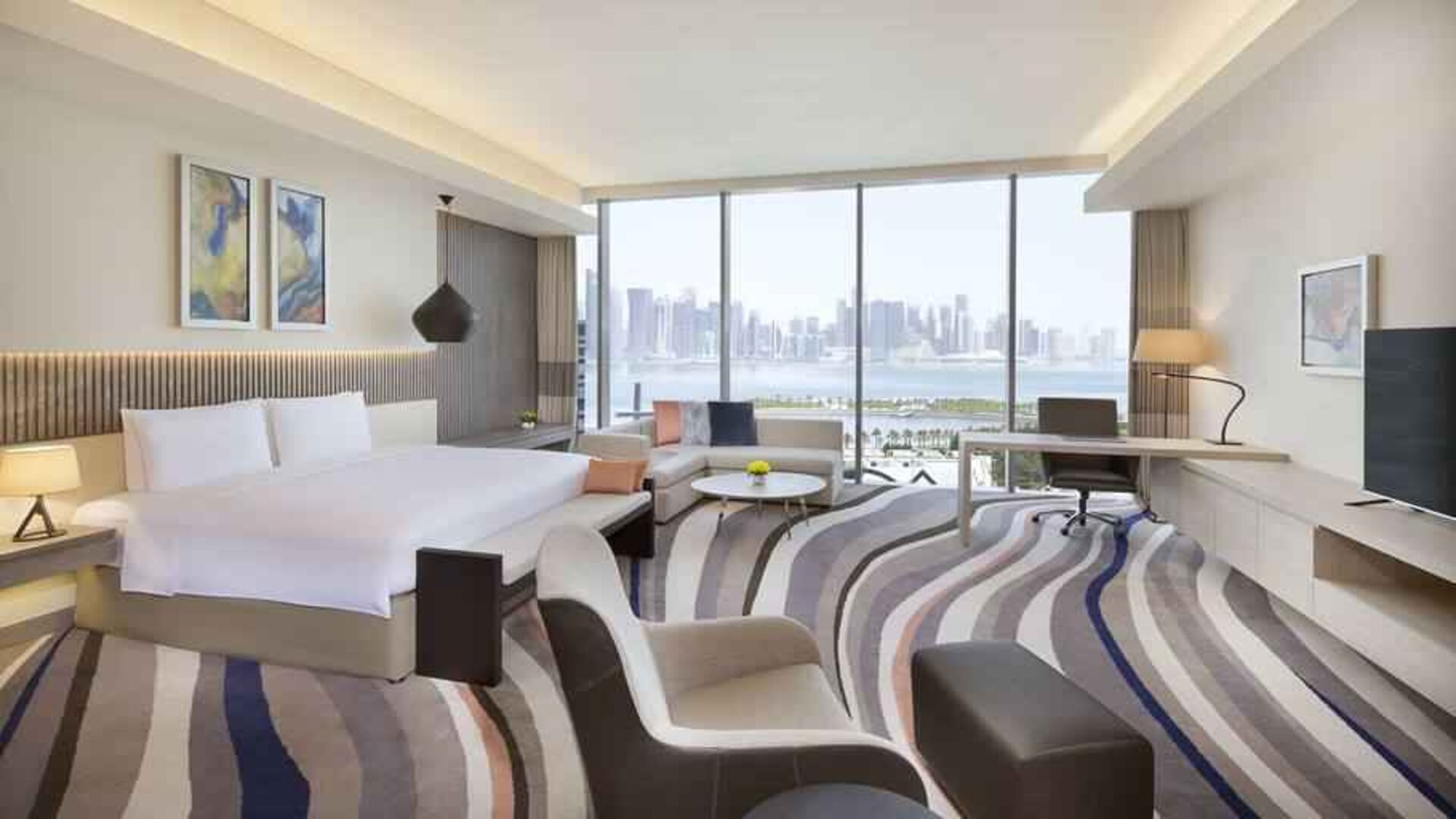 King suite with desk, sofa and TV screen at the DoubleTree by Hilton Doha - Old Town.