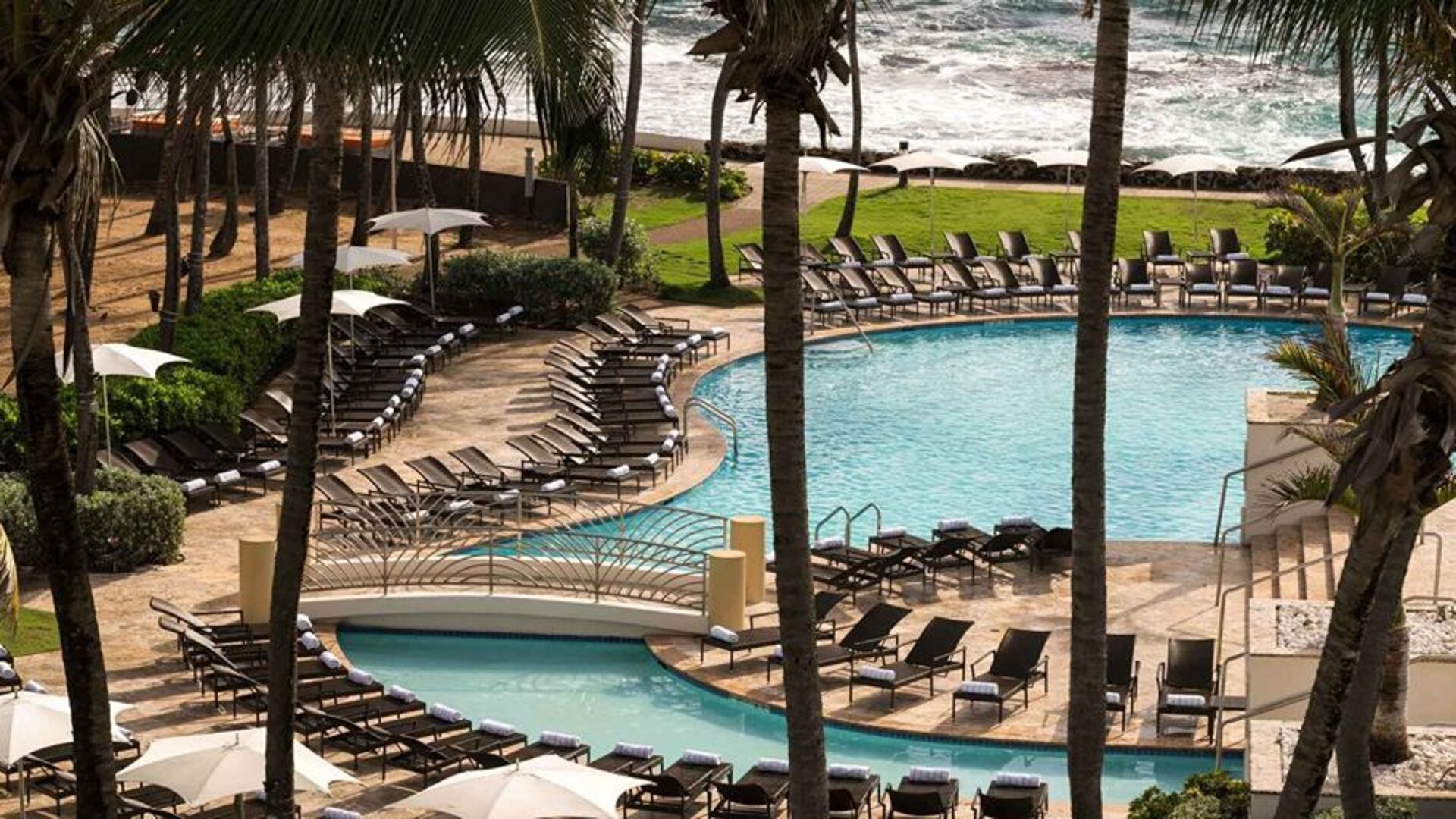Relaxing outdoor pool area with lounges at the Caribe Hilton.