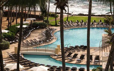 Relaxing outdoor pool area with lounges at the Caribe Hilton.