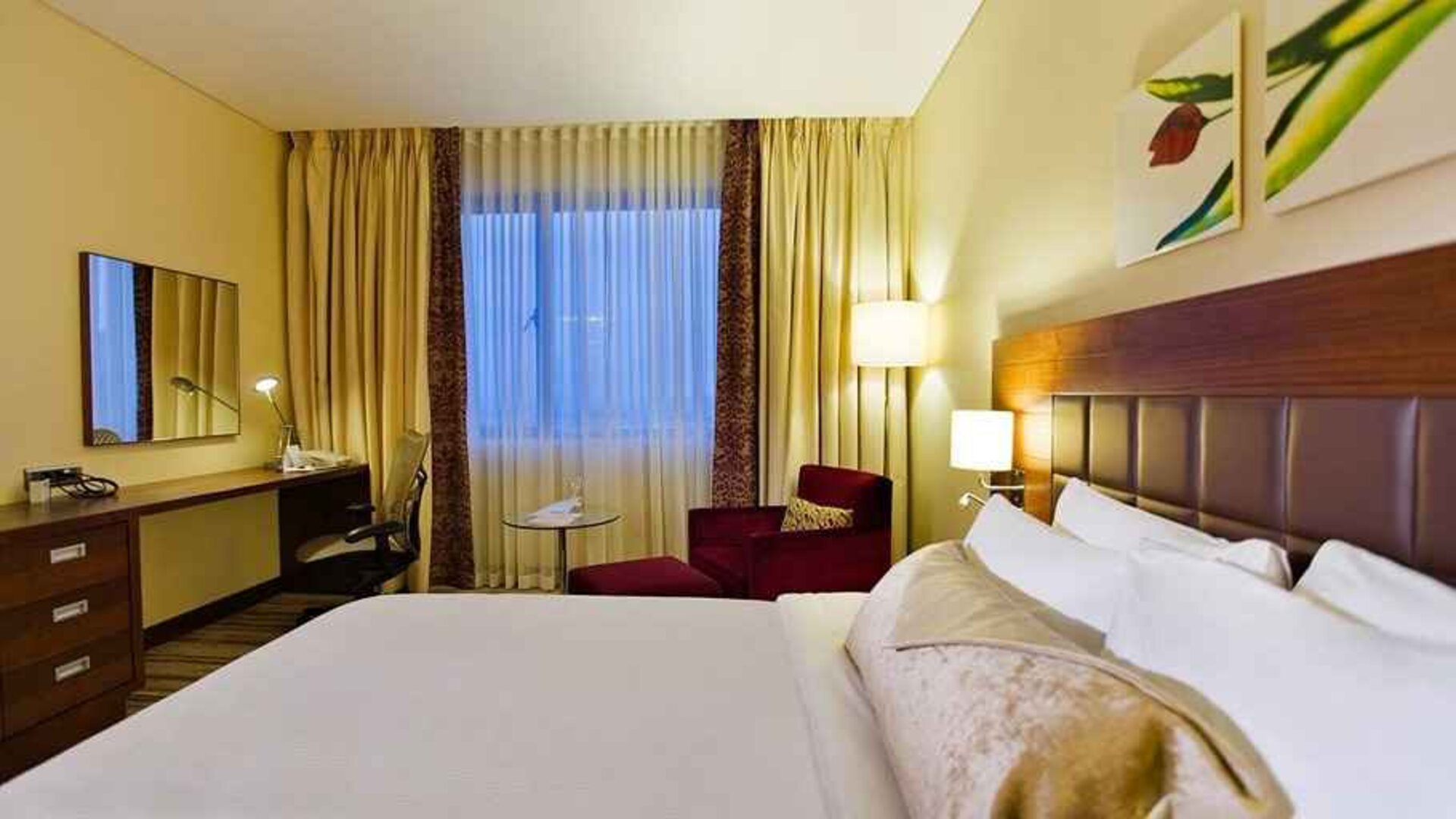 comfortable delux king room with TV, desk, chair, and couch at Hilton Garden Inn Kutahya.