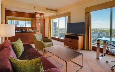 Spacious living room with view, working station and sofa at the Hilton Warsaw City.