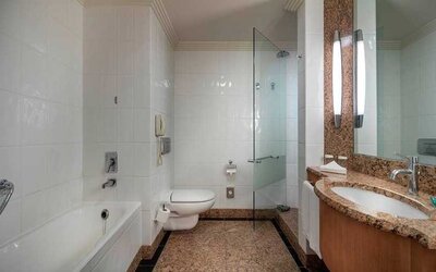 spacious bathroom with bath and shower at Adana HiltonSA.