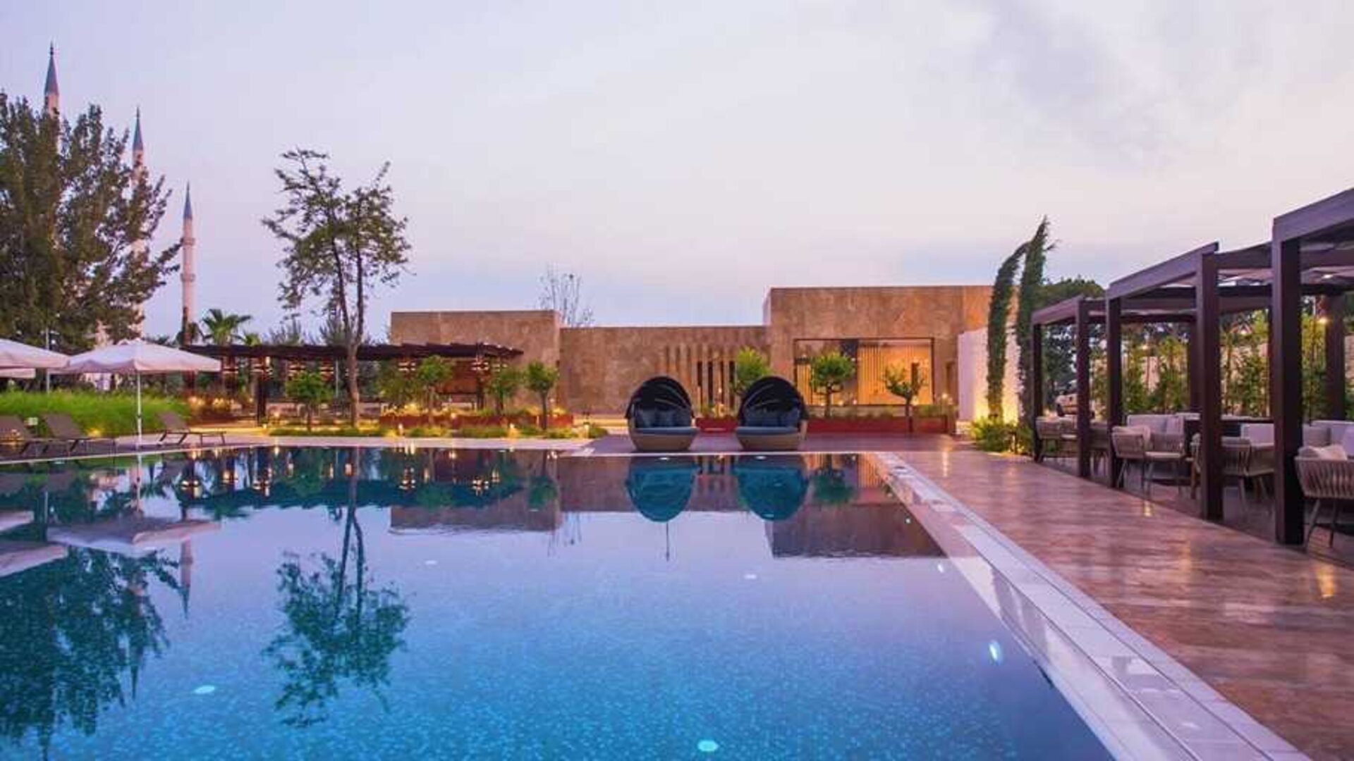 stunning outdoor pool with sun beds and seating area at Adana HiltonSA.