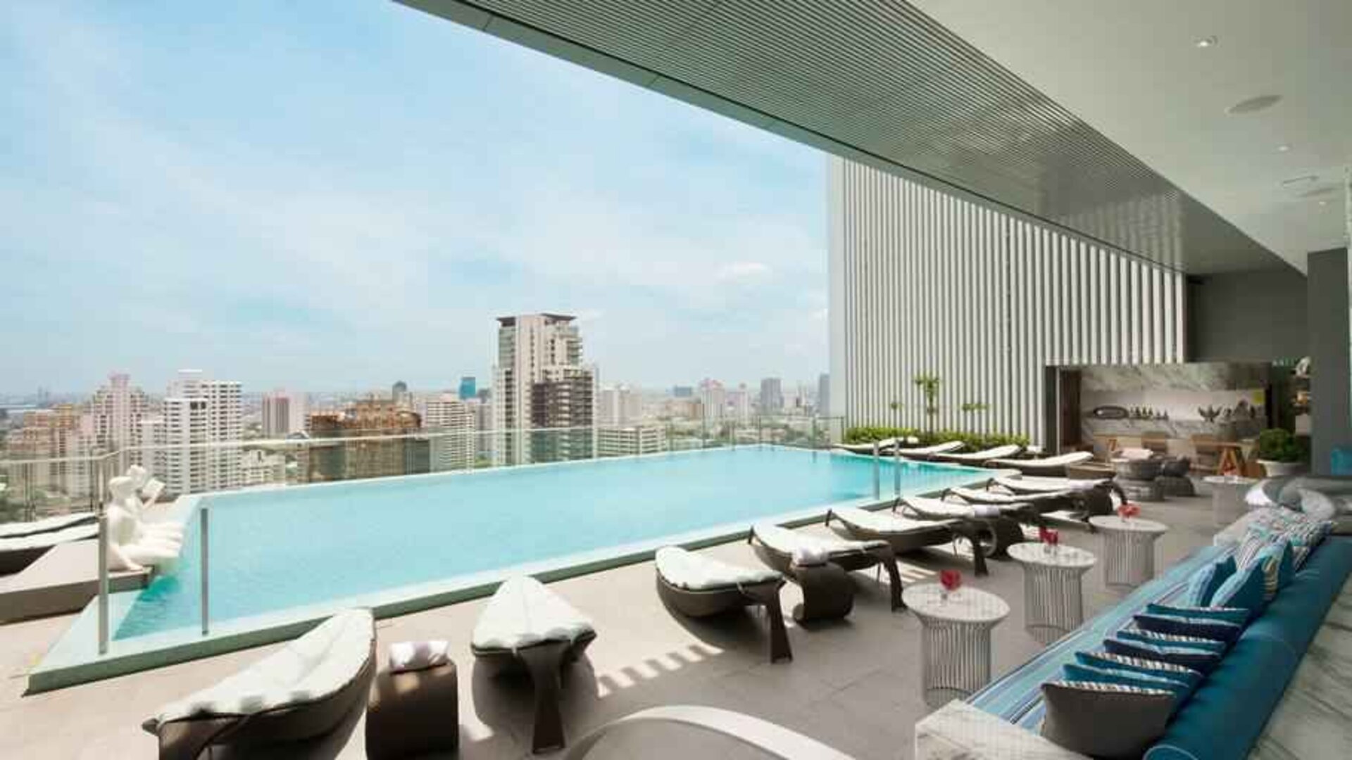 Beautiful outdoor pool with lounges overlooking the city at the Hilton Sukhumvit Bangkok.
