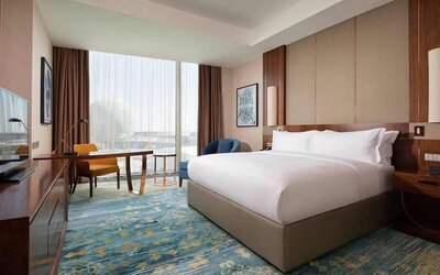spacious king room with business desk, chair, TV, and couch at Hilton Astana.