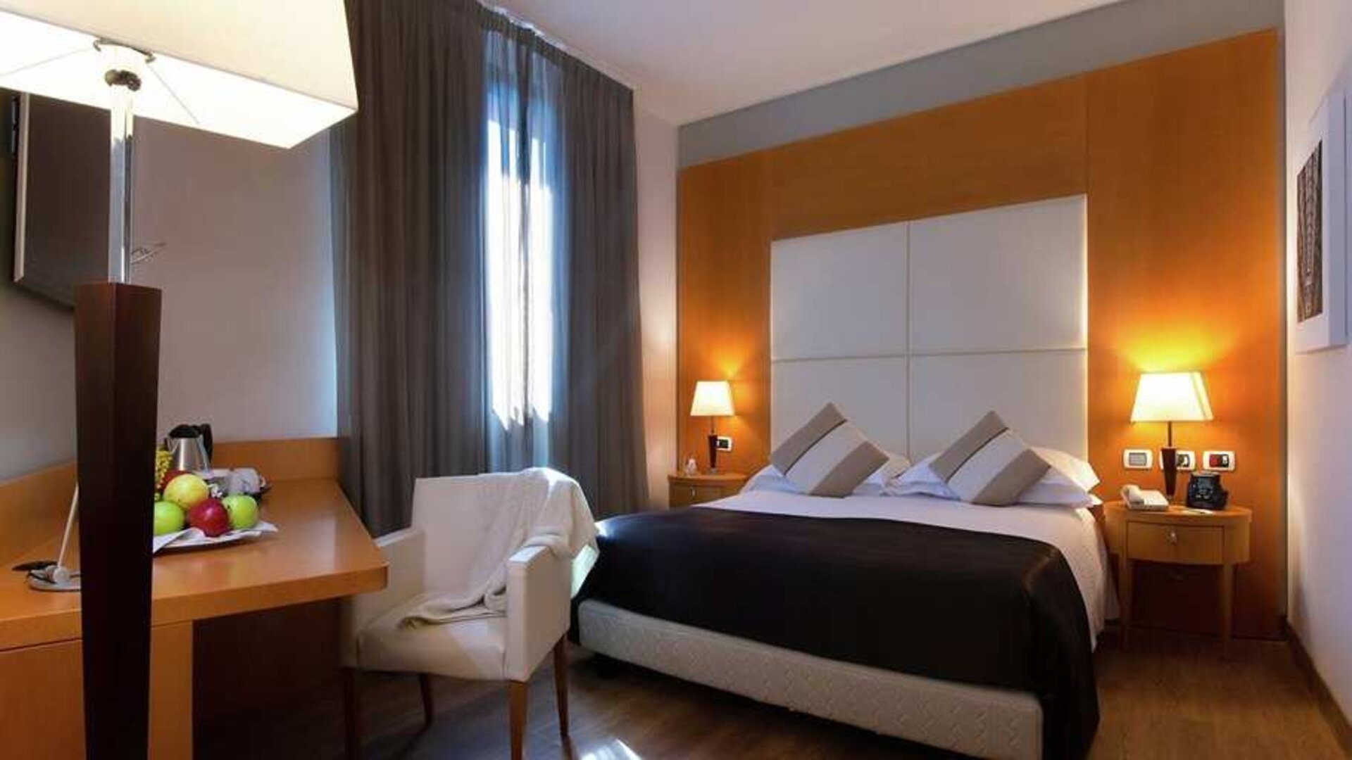 comfortable king suite with table, chair, and TV at Hilton Garden Inn Milan Malpensa.