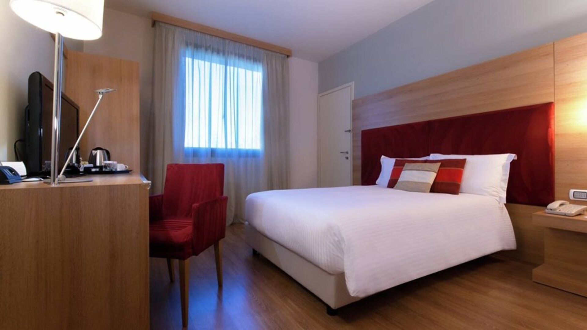 delux king room with TV, desk, and chair at Hilton Garden Inn Milan Malpensa.