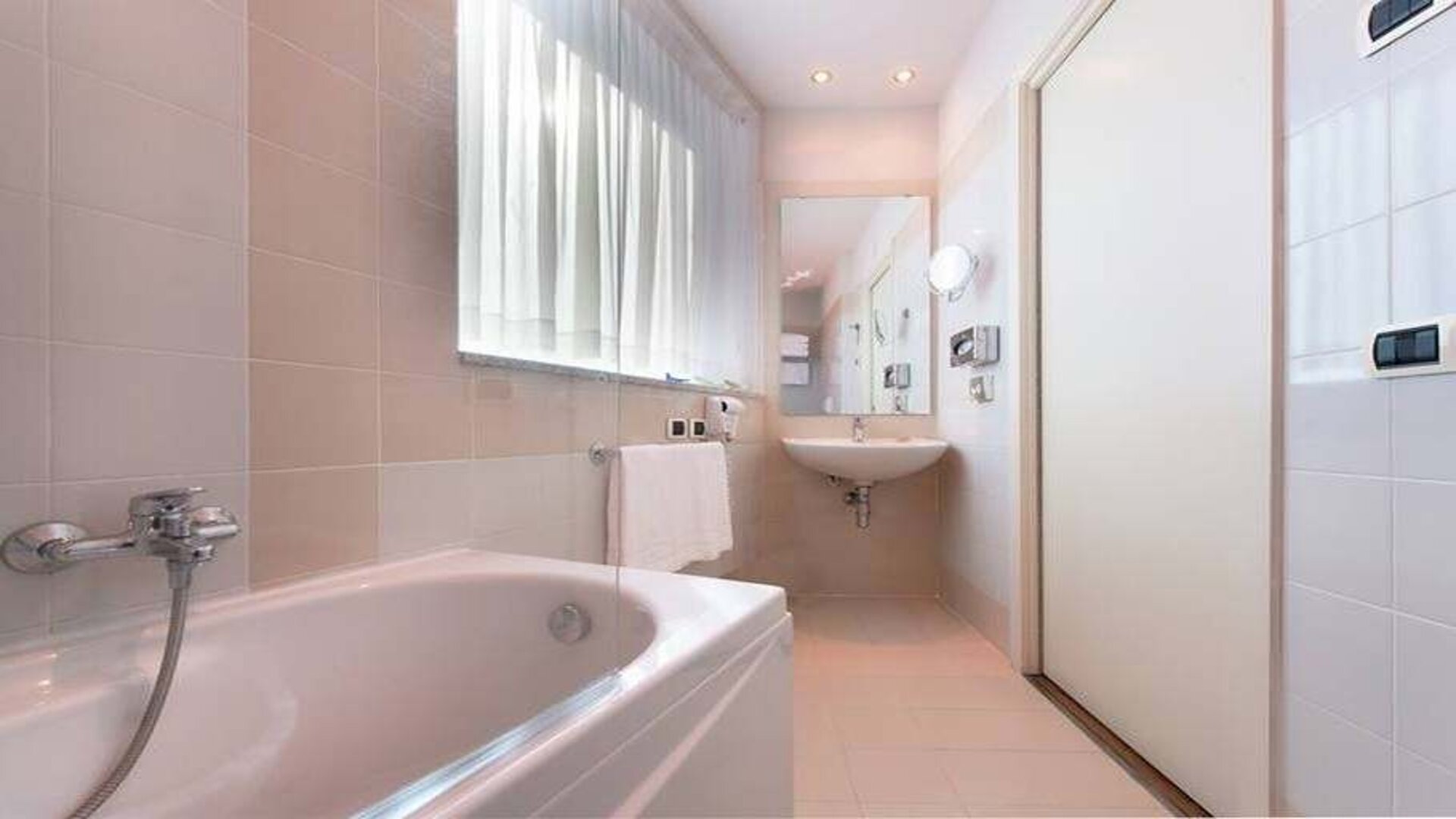 clean and spcious bathroom with bath and shower at Hilton Garden Inn Milan Malpensa.