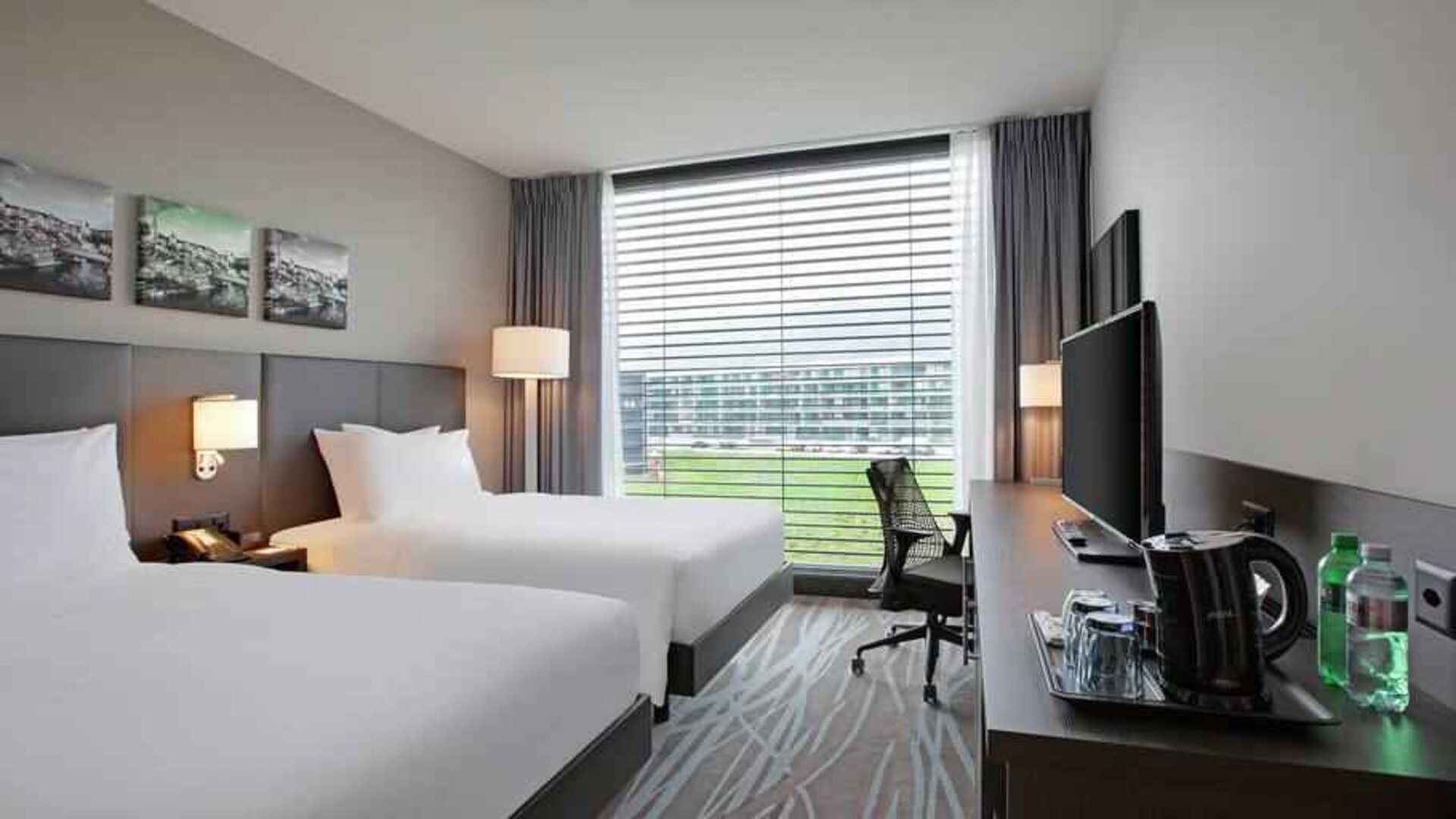 Twin room with desk and TV screen at the Hilton Garden Inn Zurich Limmattal.