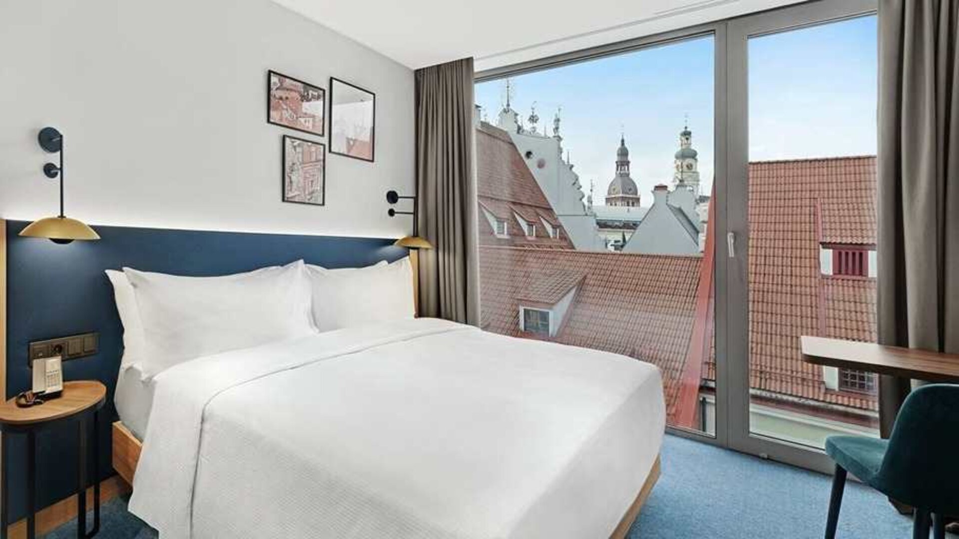 lovely delux king bedroom with chair and desk and lots of natural light at Hilton Garden Inn Riga Old Town.