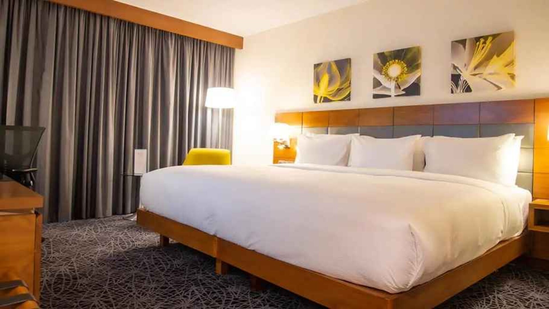 delux king room with couch, chair, and work desk at Hilton Garden Inn Nairobi Airport.