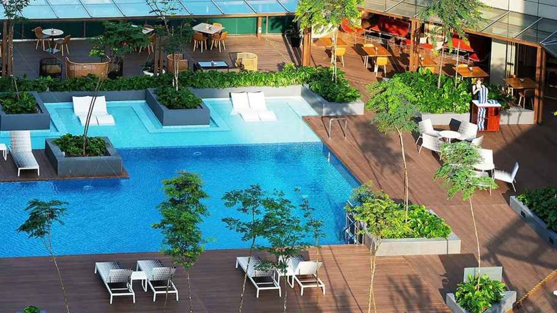 stunning outdoor pool surrounded by sun beds and seating area at DoubleTree by Hilton Hotel Johor Bahru.