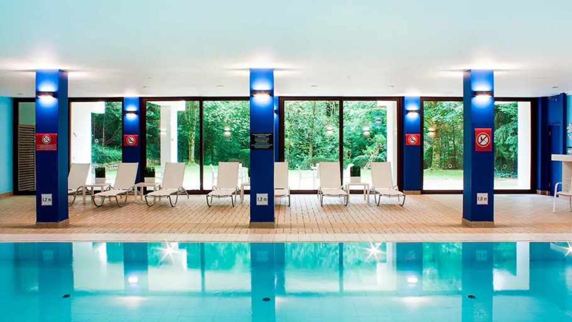 indoor pool with surrounding sunbeds at DoubleTree by Hilton Luxembourg.