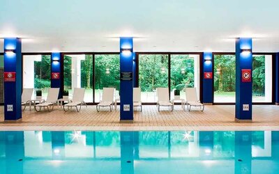 indoor pool with surrounding sunbeds at DoubleTree by Hilton Luxembourg.