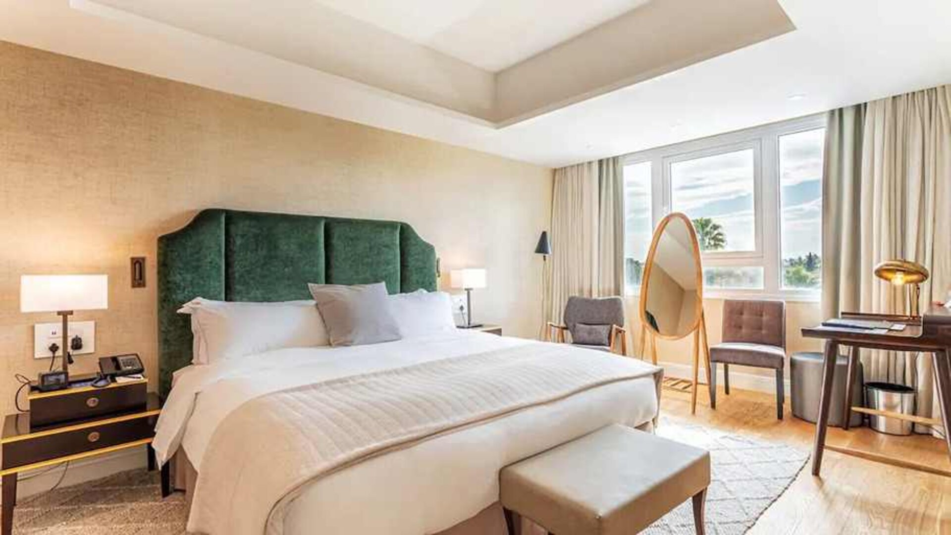 spacious king room with chair and desk and lots of natural light at Hilton Nicosia.