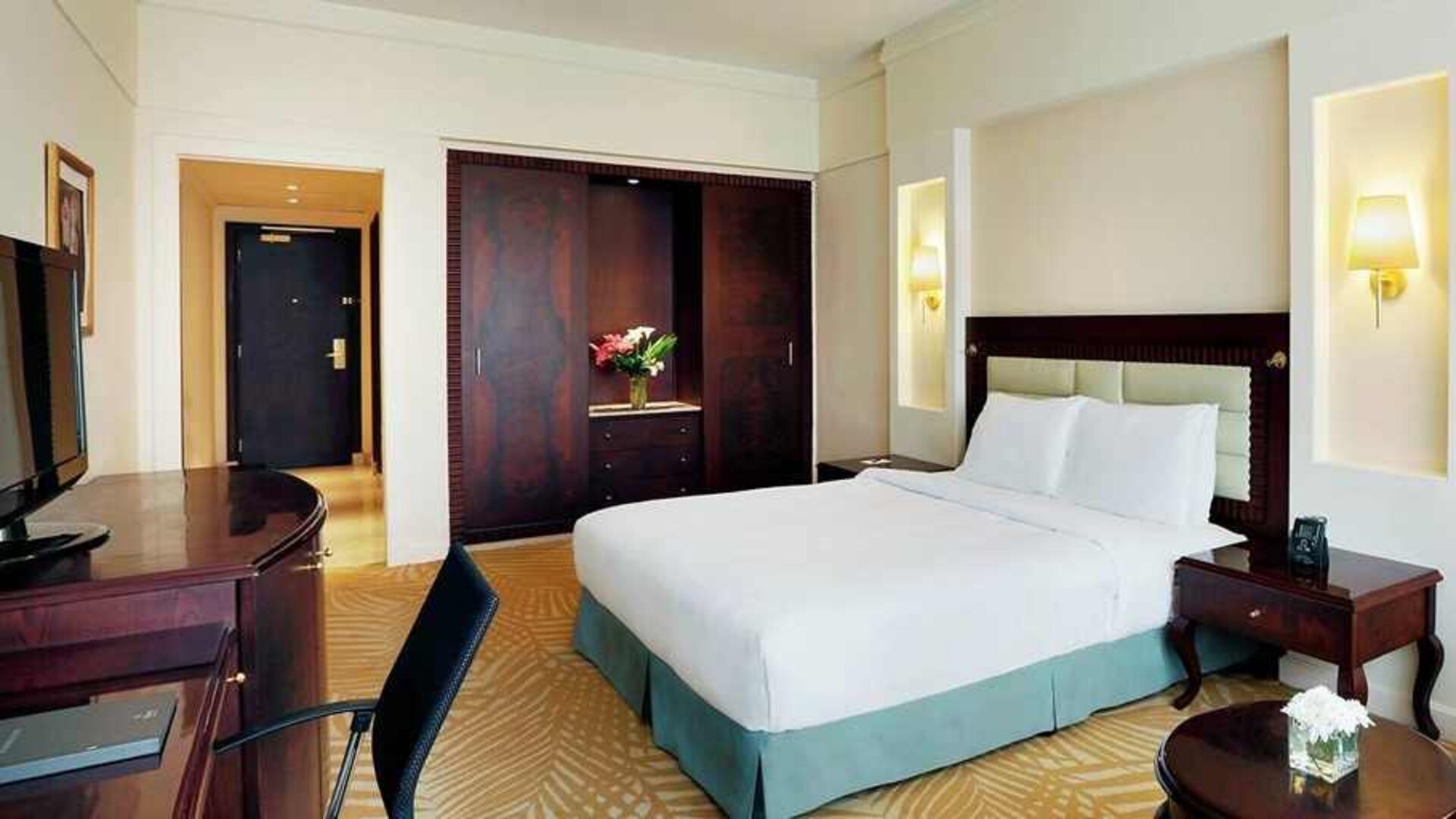 spacious king suite with TV, work desk, and chair at Hilton Alexandria Green Plaza.