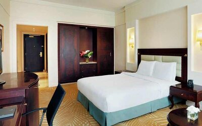 spacious king suite with TV, work desk, and chair at Hilton Alexandria Green Plaza.